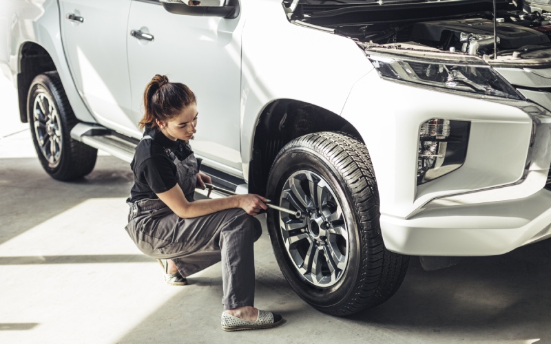 high angle female mechanic taking out wheel